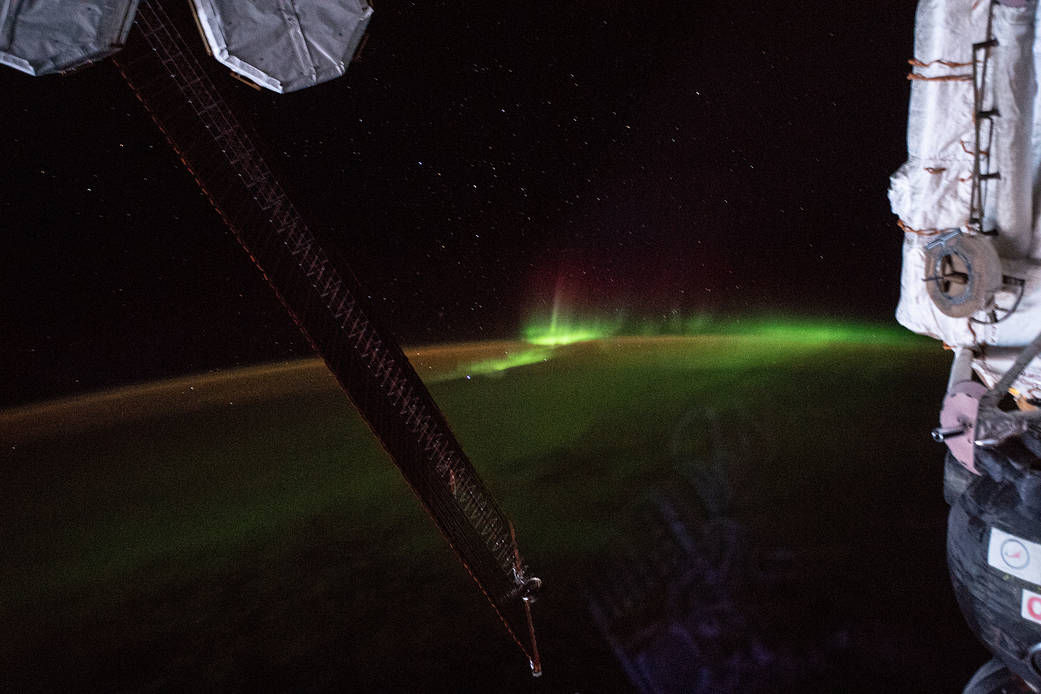 Green aurora above Earth's curved horizon, photographed from the International Space Station in April 2019.
