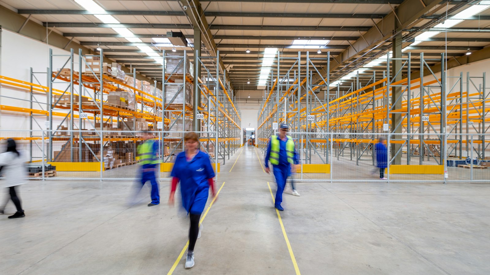 Workers walking through a warehouse aisle