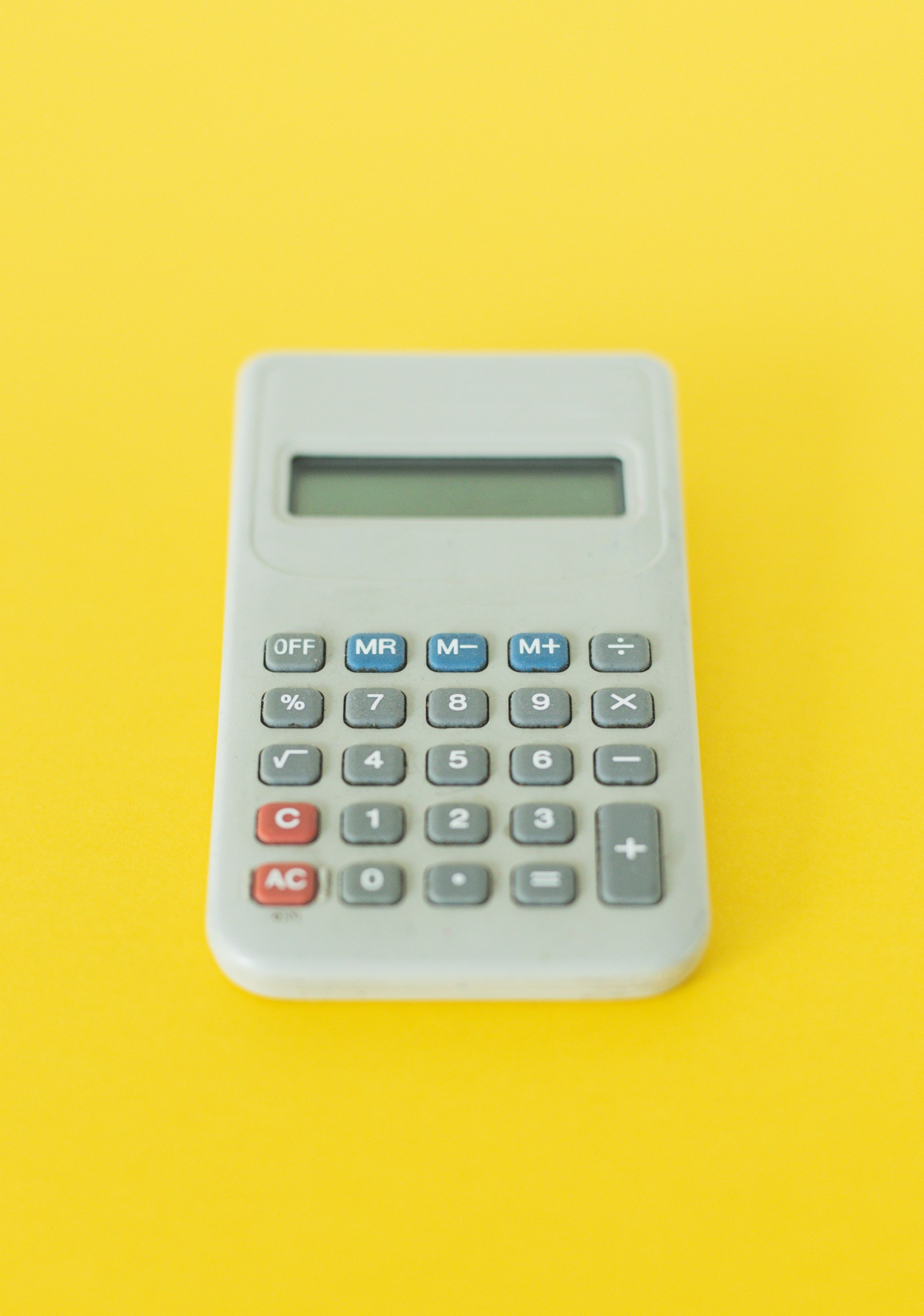 A calculator on a yellow background.