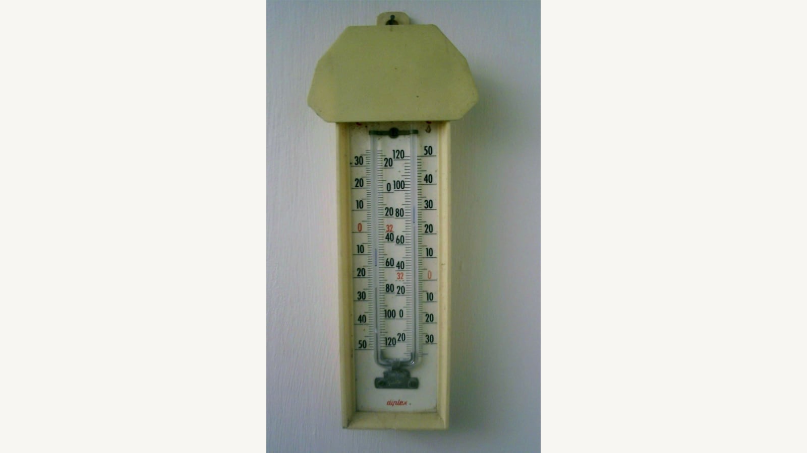 A maximum and minimum thermometer mounted on a wall. Illustrative photograph, not a current Australian temperature reading.