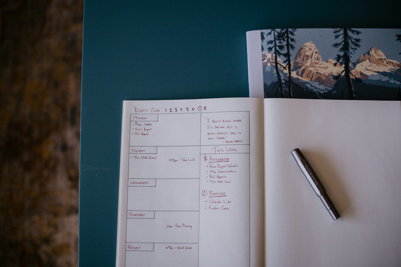 Open notebook with a task list and pen on a desk.