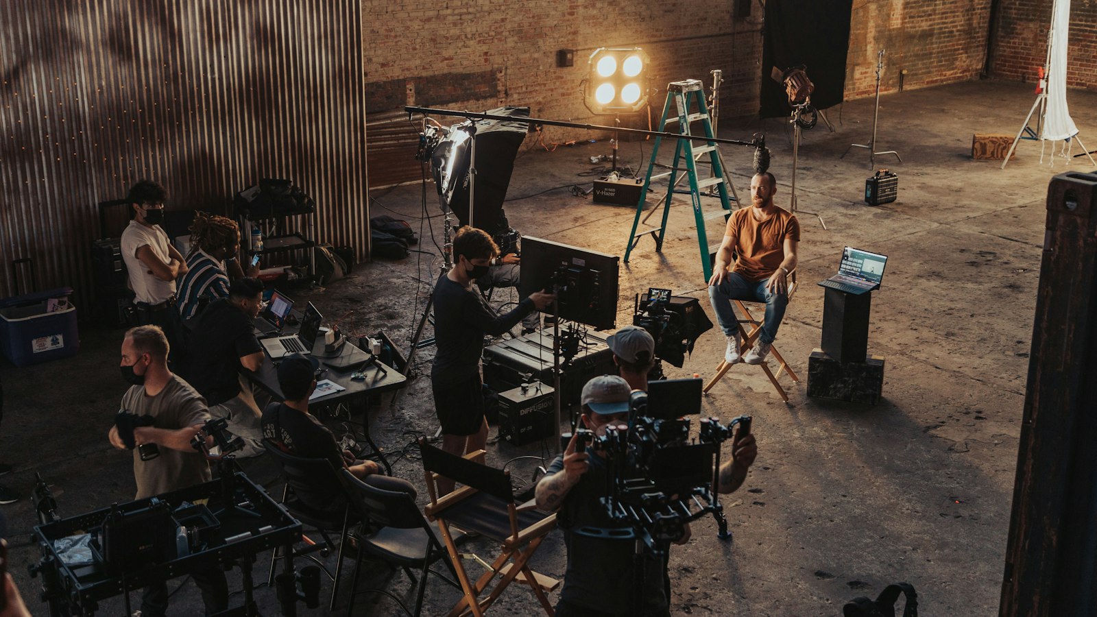 A film crew gathered around a camera on set