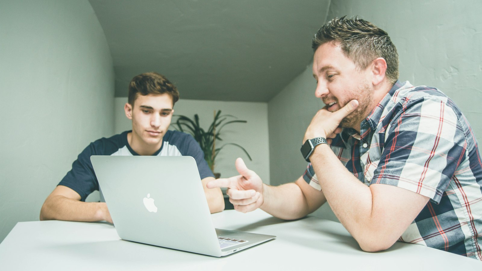 Two colleagues discussing work on a laptop