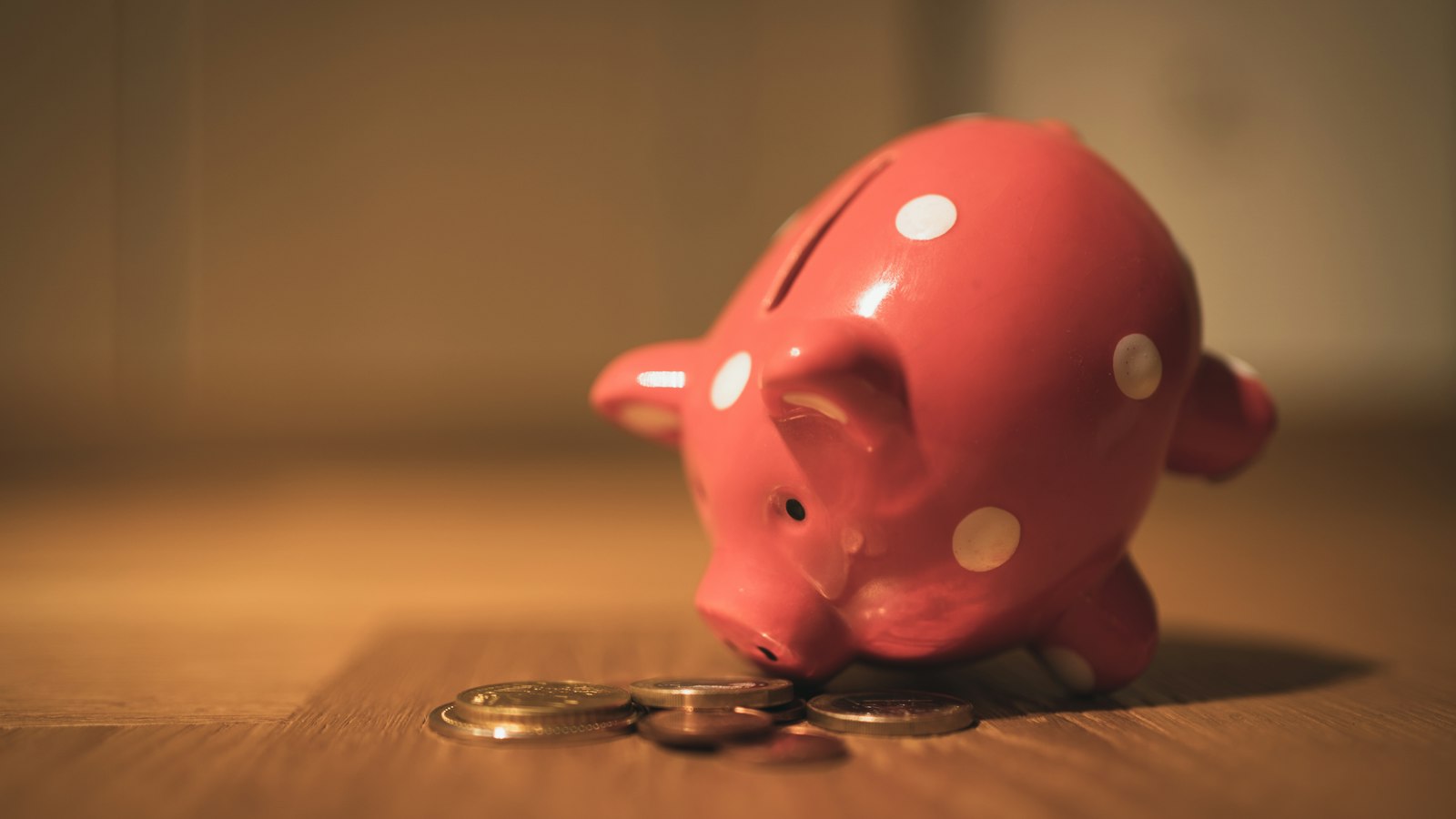 A pink piggy bank on a wooden table