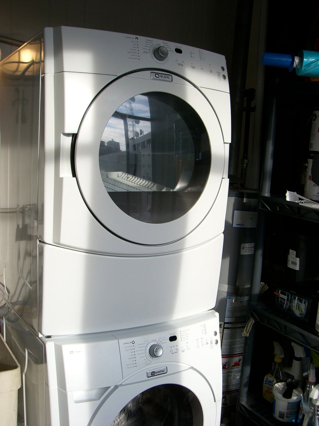 A washing machine and clothes dryer stacked in a laundry.