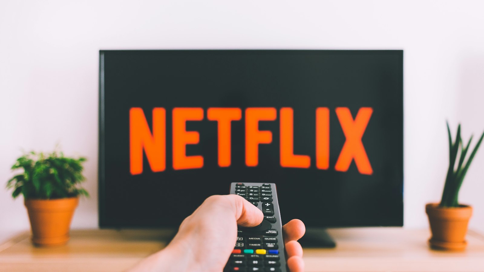 A person pointing a remote control at a television