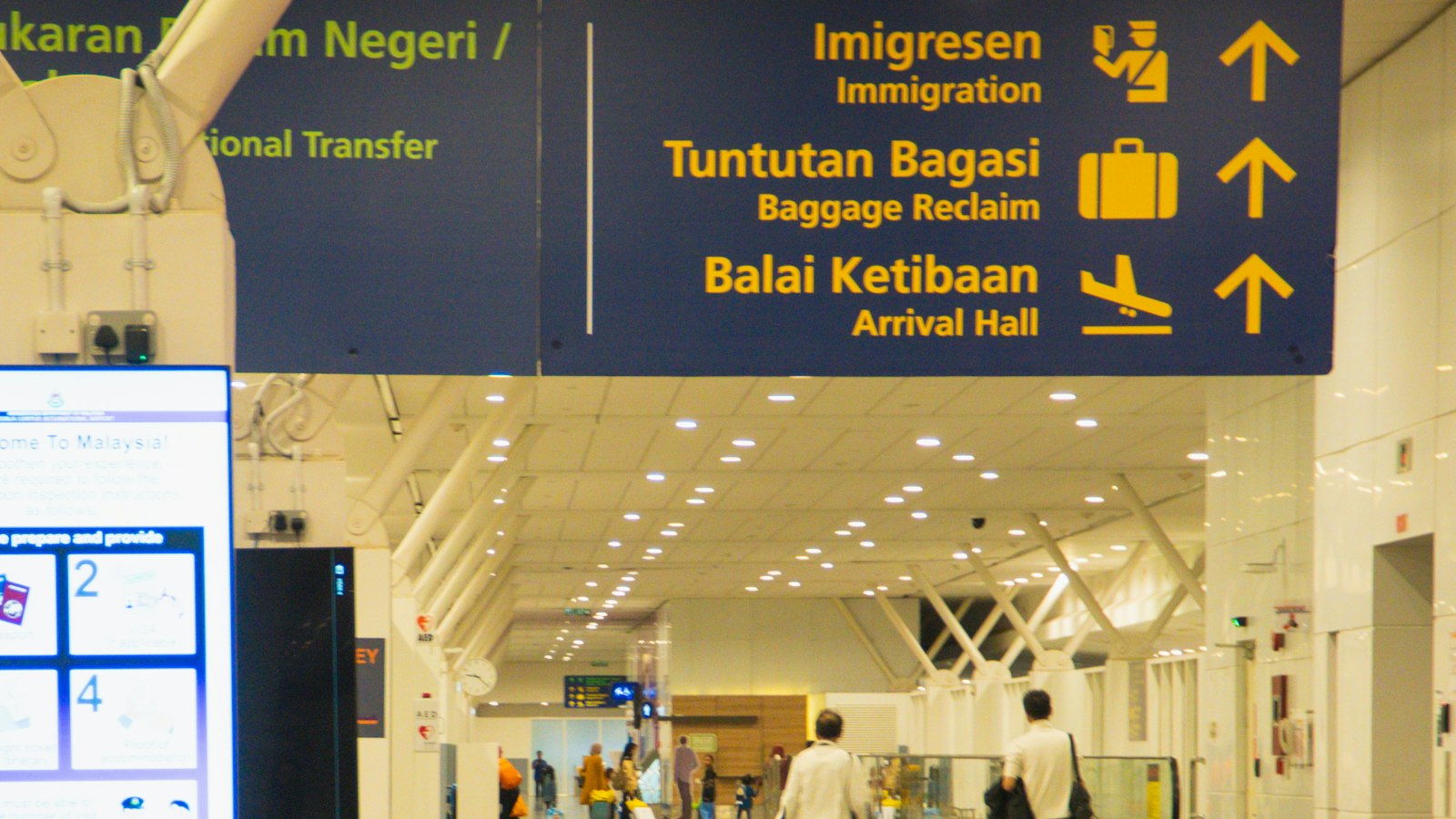 An airport hallway with signs for immigration and baggage claim