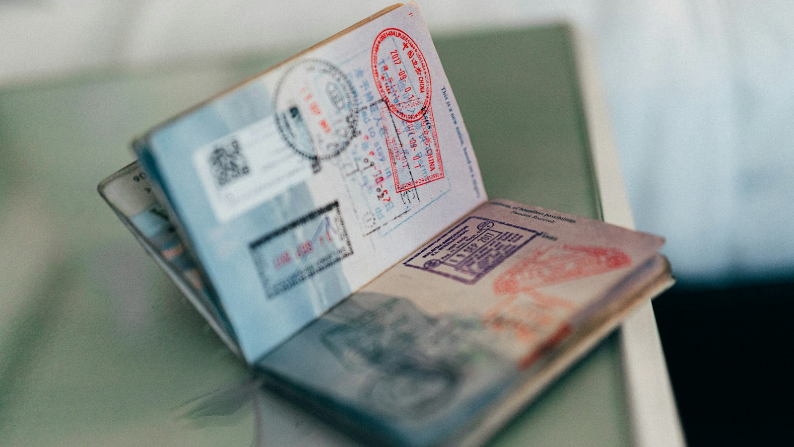 An open passport with colourful ink stamps