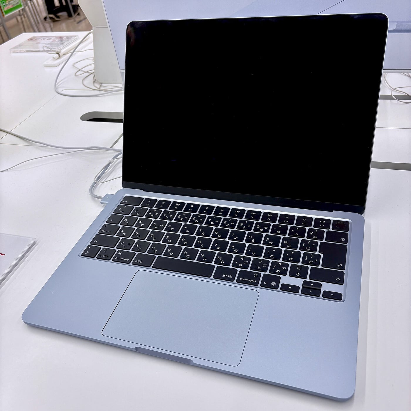 A sky-blue 13-inch MacBook Air M5 on display in a shop.